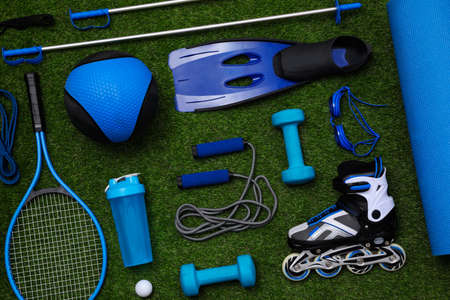 Different sport equipment on green grass, flat layの写真素材