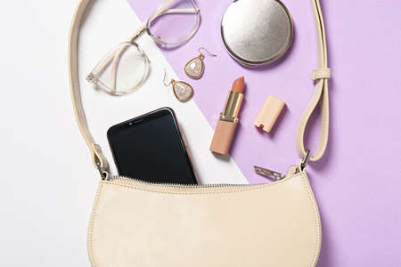 Stylish women's bag and different stuff on color background, flat lay
