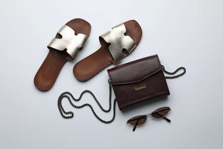 Stylish woman's bag, sunglasses and shoes on light background, flat layの写真素材