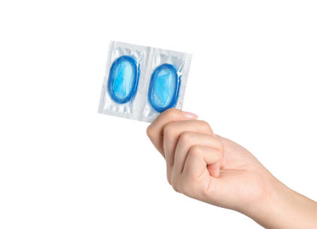 Woman holding condoms on white background, closeupの写真素材