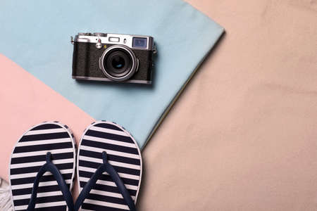 Beach towel, camera and flip flops on sand, flat lay. Space for textの写真素材