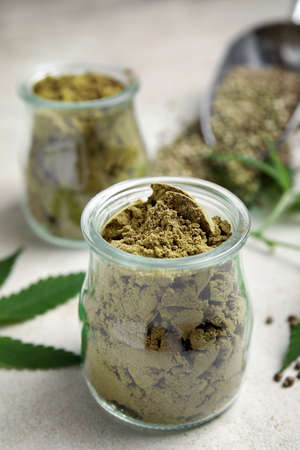 Hemp protein powder on light gray table, closeup