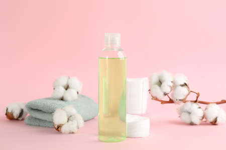 Cotton pads, towel, dry flowers and makeup removal product on pink backgroundの写真素材