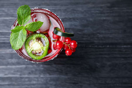 Spicy red currant cocktail with jalapeno and mint on black wooden table, top view. Space for textの写真素材