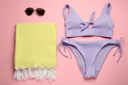 Beach towel, swimsuit and sunglasses on pink background, flat layの写真素材