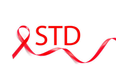 Red awareness ribbon and abbreviation STD on white background, top view