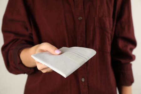 Woman holding handkerchief against light background, closeupの写真素材