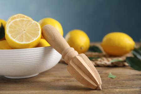 Squeezer with lemons on wooden table, closeupの写真素材