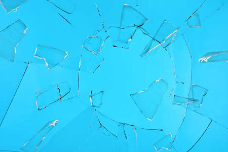 Broken glass with cracks on blue backgroundの写真素材