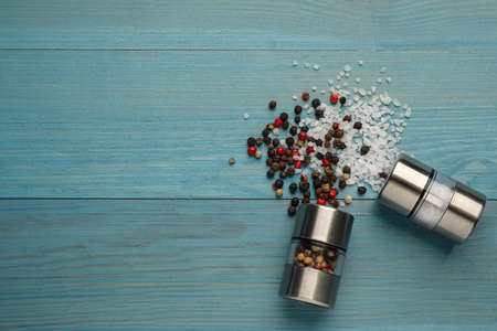 Salt and pepper shakers on turquoise wooden table, flat lay. Space for textの写真素材