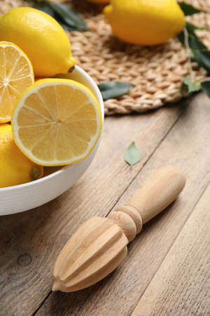Squeezer with lemons on wooden table, closeupの写真素材