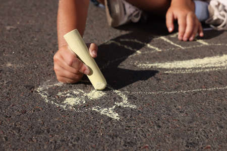 Little child drawing cat with colorful chalk on asphalt, closeupの写真素材