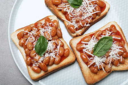 Toasts with delicious canned beans on light gray table, top viewの写真素材