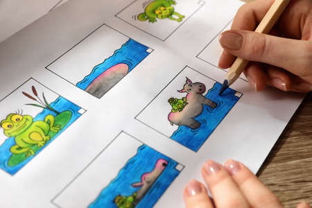 Woman drawing cartoon sketch in storyboard at workplace, closeup. Pre-production processの写真素材