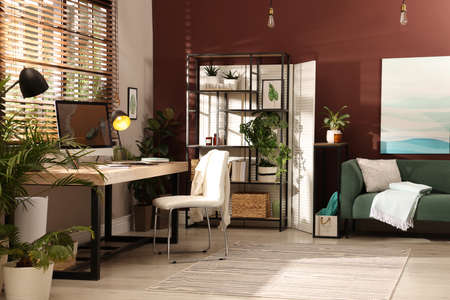 Light room interior with comfortable workplace near window