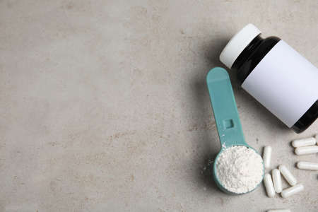 Amino acid pills and powder on gray table, flat lay. Space for textの写真素材