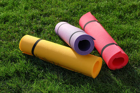 Bright exercise mats on fresh green grass outdoorsの写真素材