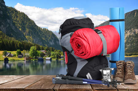 Camping equipment for tourist on wooden surface and beautiful view of mountain landscapeの写真素材