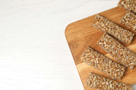 Delicious sweet kozinaki bars on white wooden table, top view. Space for textの写真素材