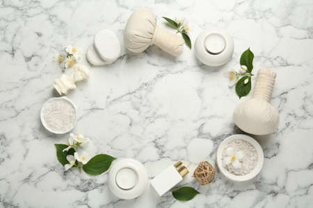 Jasmine flowers and set of spa essentials on white marble table, flat lay. Space for textの写真素材
