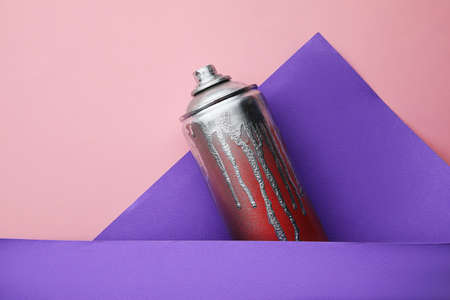 Used can of spray paint on color background, top view. Graffiti supplyの写真素材