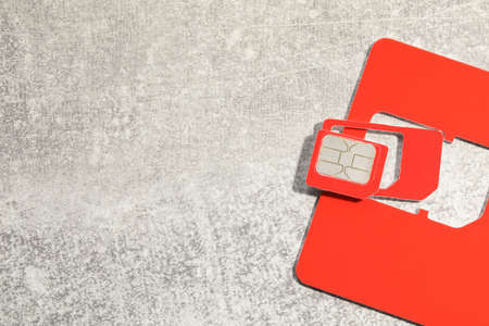 Multi SIM card on light gray stone background, top view. Space for textの写真素材