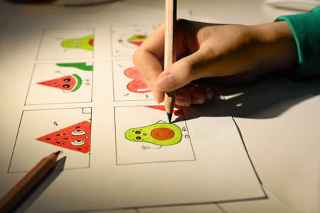 Woman drawing cartoon sketch at workplace, closeup. Pre-production process