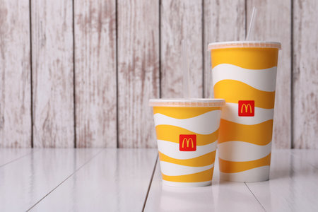 MYKOLAIV, UKRAINE - AUGUST 12, 2021: Cold McDonald's drinks on white wooden table. Space for textのeditorial素材
