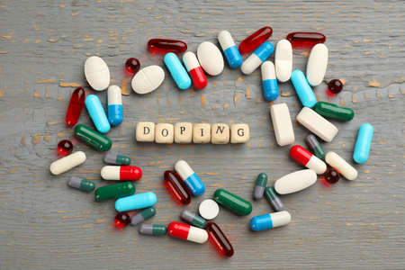 Cubes with word Doping and drugs on light gray wooden background, flat layの写真素材