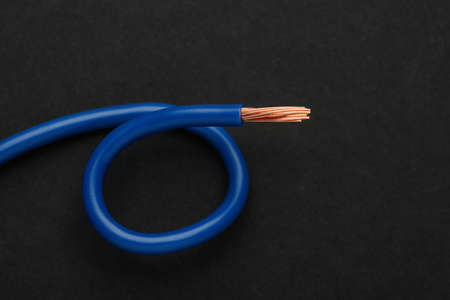 Blue electrical wire on black background, top view
