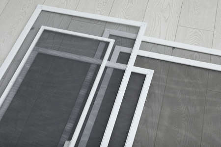 Set of window screens on wooden floor, above view