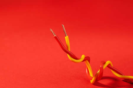 Two different electrical wires on red background. Space for textの写真素材