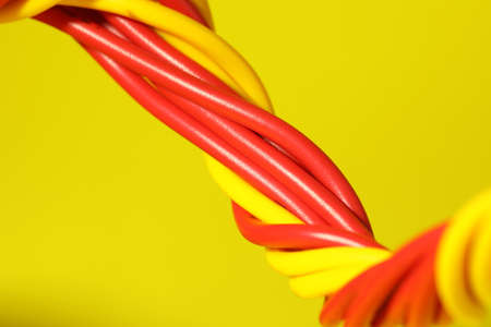 Electrical wires on yellow background, closeup viewの写真素材