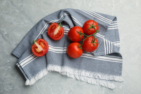 Kitchen towel and fresh tomatoes on gray table, flat layの写真素材