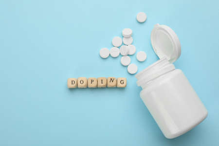 Wooden cubes with word Doping and drugs on turquoise background, flat layの写真素材