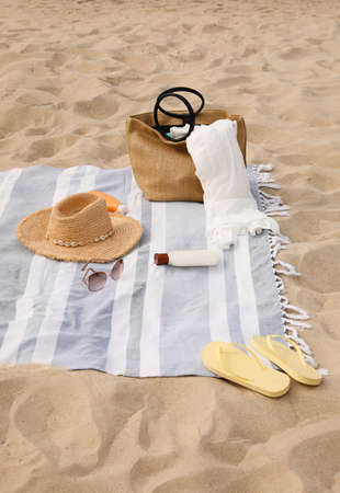Bag and other beach items on sandの写真素材