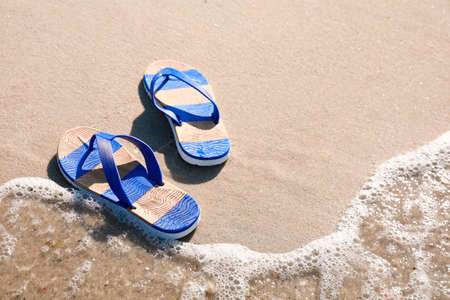 Stylish flip flops on beach. Space for textの写真素材