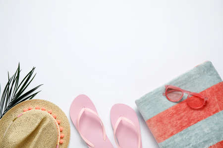 Beach towel, flip flops, hat and sunglasses on white background, flat lay. Space for textの写真素材