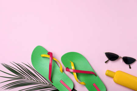 Stylish flip flops and beach objects on pink background, flat lay. Space for textの写真素材