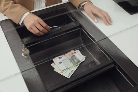 Cashier with money at bank, closeup. Currency exchange