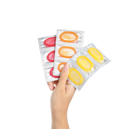 Woman holding condoms on white background, closeupの写真素材