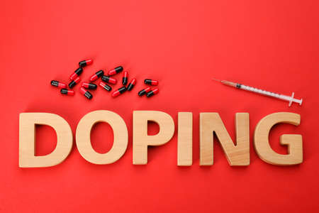 Word Doping and drugs on red background, flat layの写真素材
