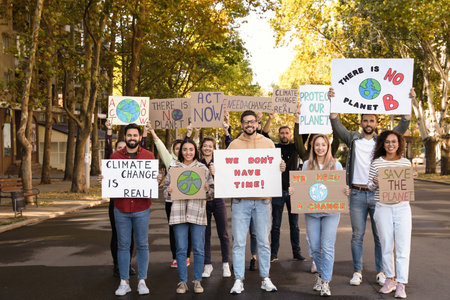 Group of people with posters protesting against climate change on city streetの写真素材