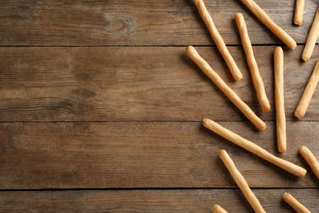 Delicious grissini sticks on wooden table, flat lay. Space for textの写真素材