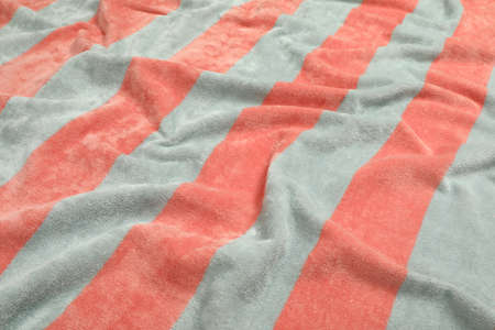 Crumpled striped beach towel as background, closeup view