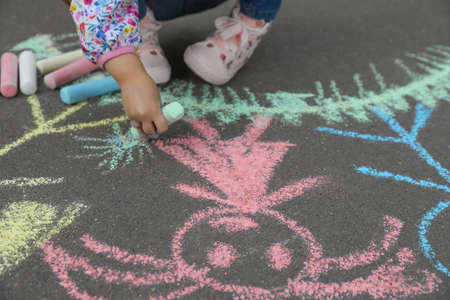 Child drawing family with chalk on asphalt, closeupの写真素材