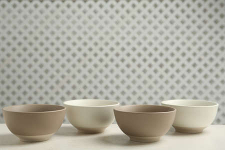 Stylish empty ceramic bowls on white wooden table, space for text. Cooking utensilsの写真素材