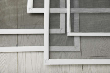 Set of window screens on wooden floor, closeup