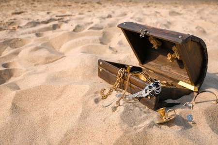 Open wooden chest with treasures on sand, space for textの写真素材