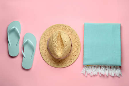 Beach towel, flip flops and straw hat on pink background, flat layの写真素材
